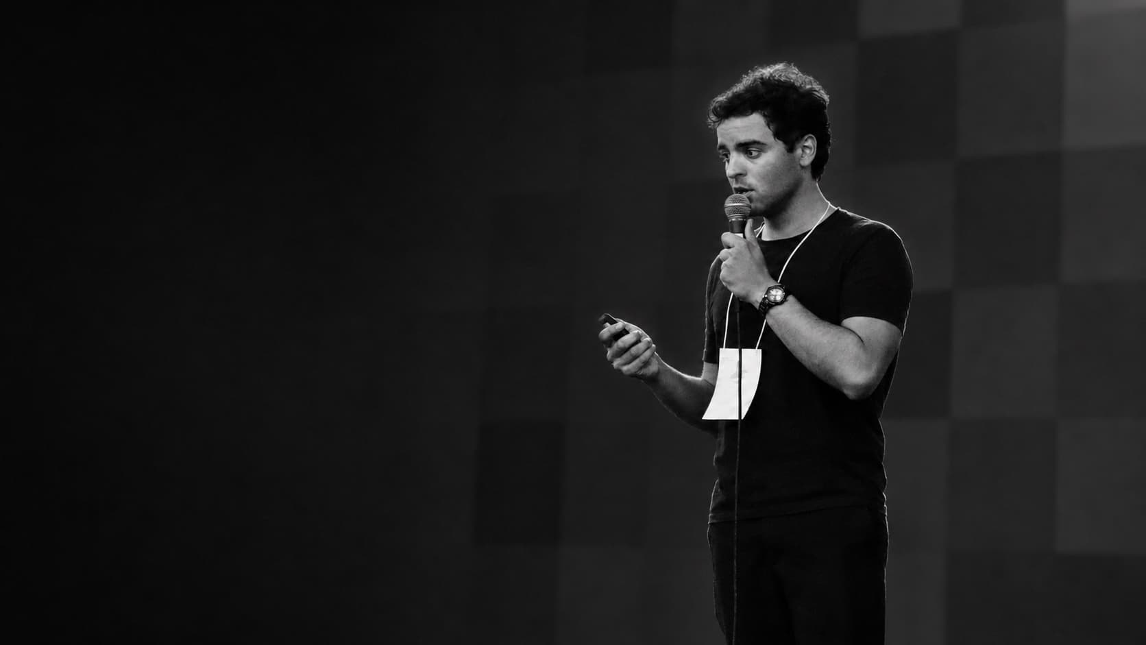 Vinicius Brigido apresentando em um evento de startups com microfone e controle de slides.